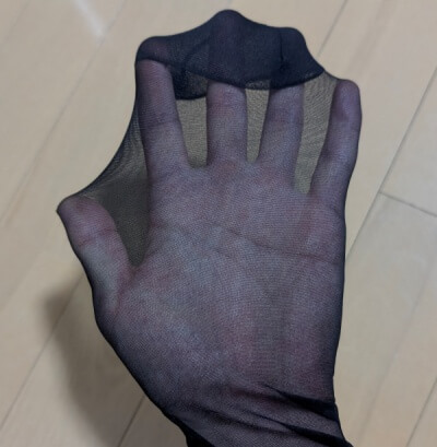 オーソドックスな黒パンストを手に被せ、その目の粗さや透け感を確かめている様子